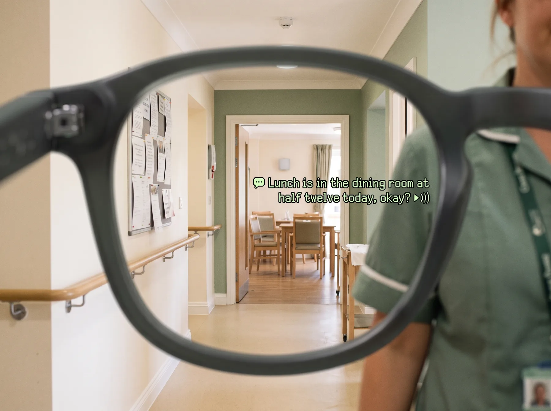 Through the lens: a caption in a care home corridor pointing toward a carer just out of view